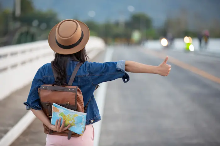 chica esperando movilidad intentando viajar con poco dinero