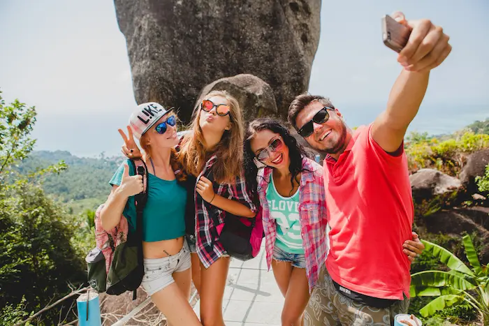 un grupo de amigos tomandose fotos para tener recuerdos de su viaje de verano