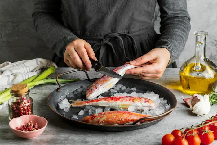 persona cocinando  pescado en semana santa 