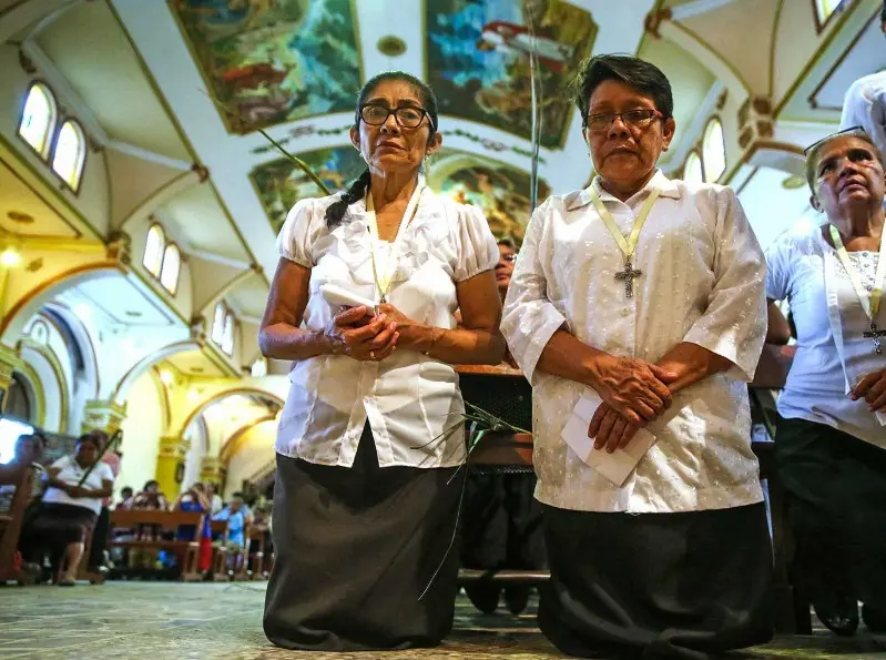 señoras en una iglesia orando