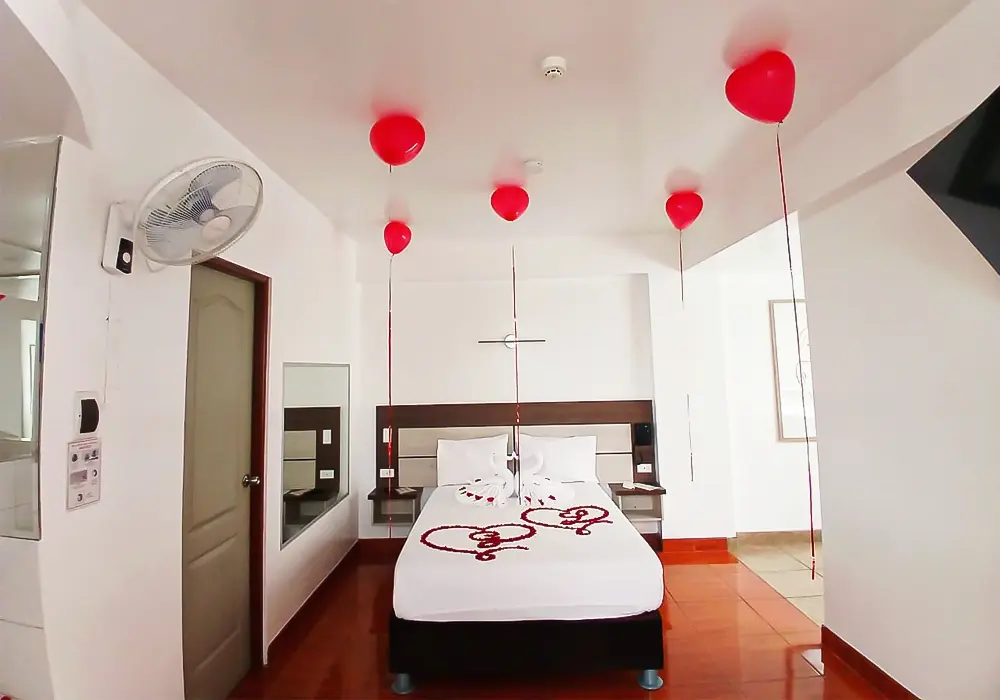 cuarto decorado de manera romantica con globos y petalos de rosa