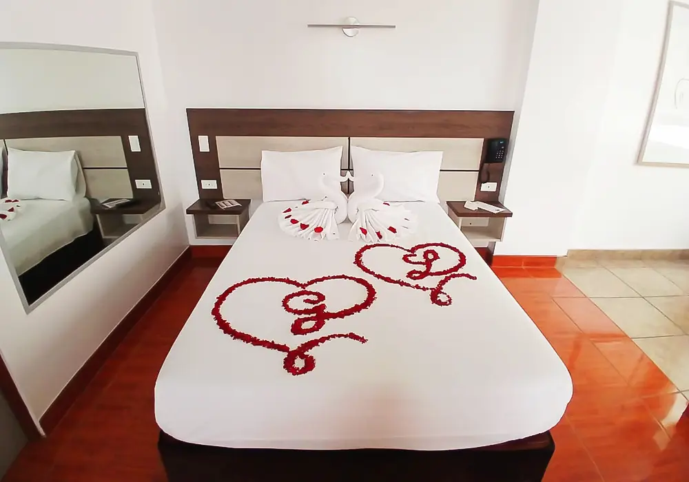 decoracion romantica de una cama con petalos de rosas formando corazones